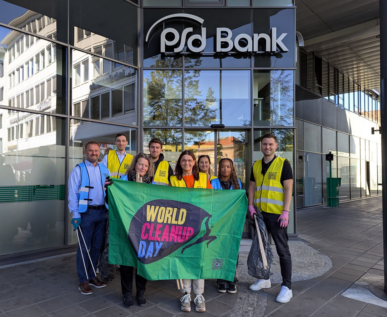 Ein Gruppe von Kolleg:innen stehen vor der PSD Bank Nürnberg.