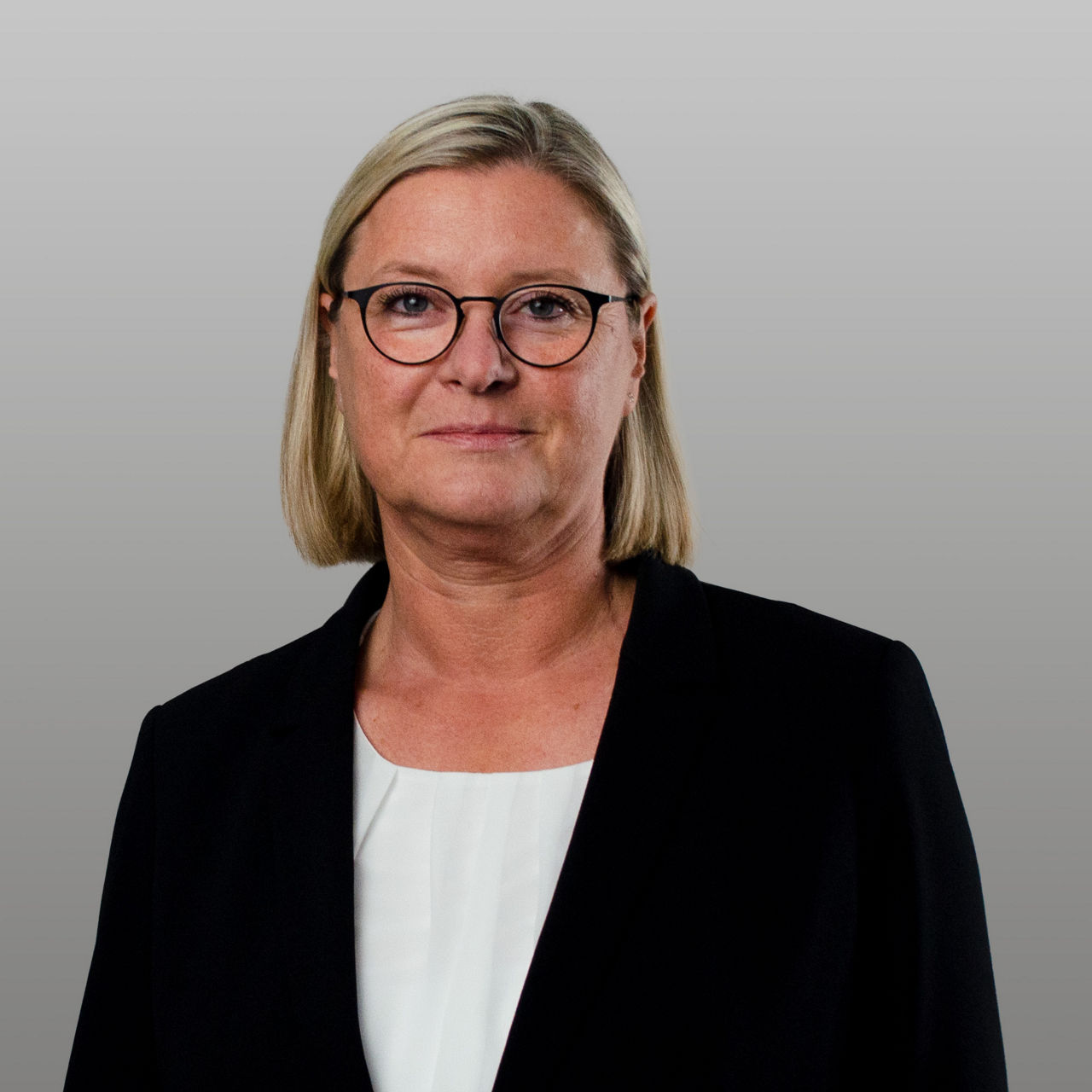 Firmenkundenberaterin Christina Wortmann vor grauem Hintergrund