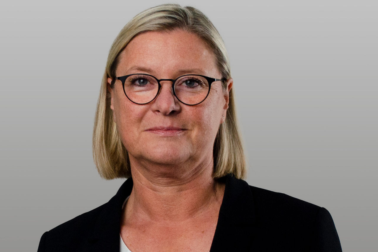 Firmenkundenberaterin Christina Wortmann vor grauem Hintergrund