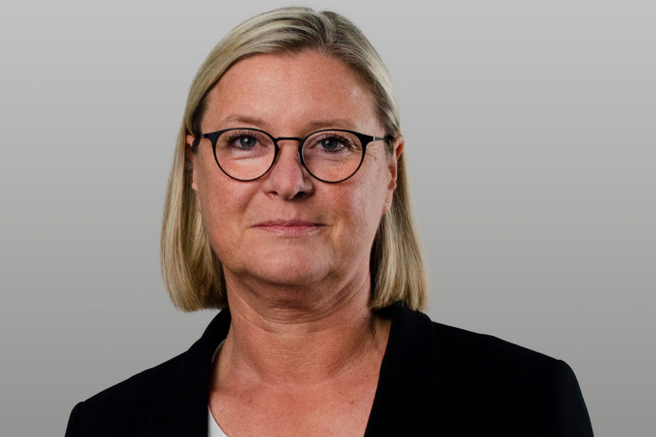 Firmenkundenberaterin Christina Wortmann vor grauem Hintergrund