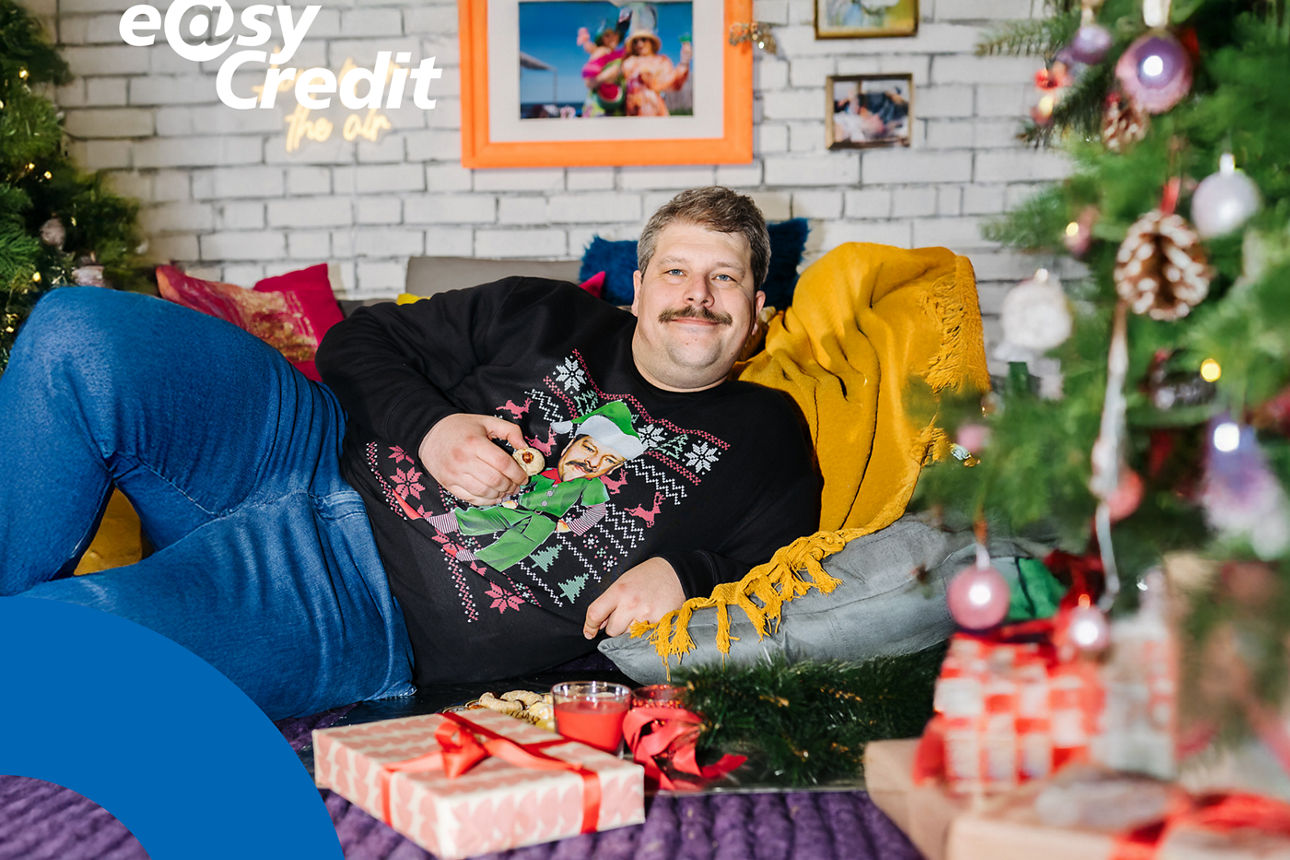 Ein Mann im Weihnachtspullover liegt auf dem Boden.