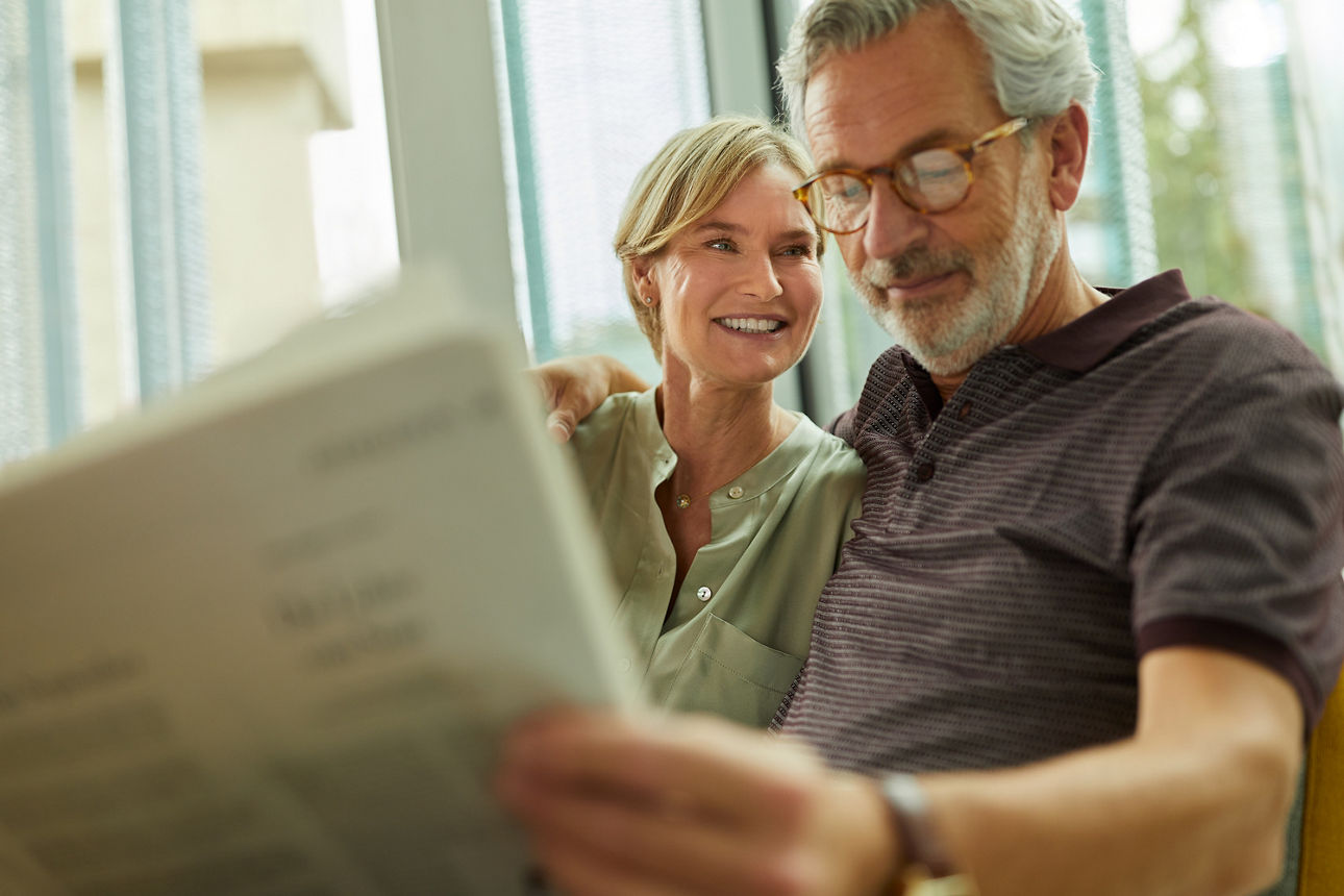 Mann und Frau lesen gemeinsam eine Zeitung