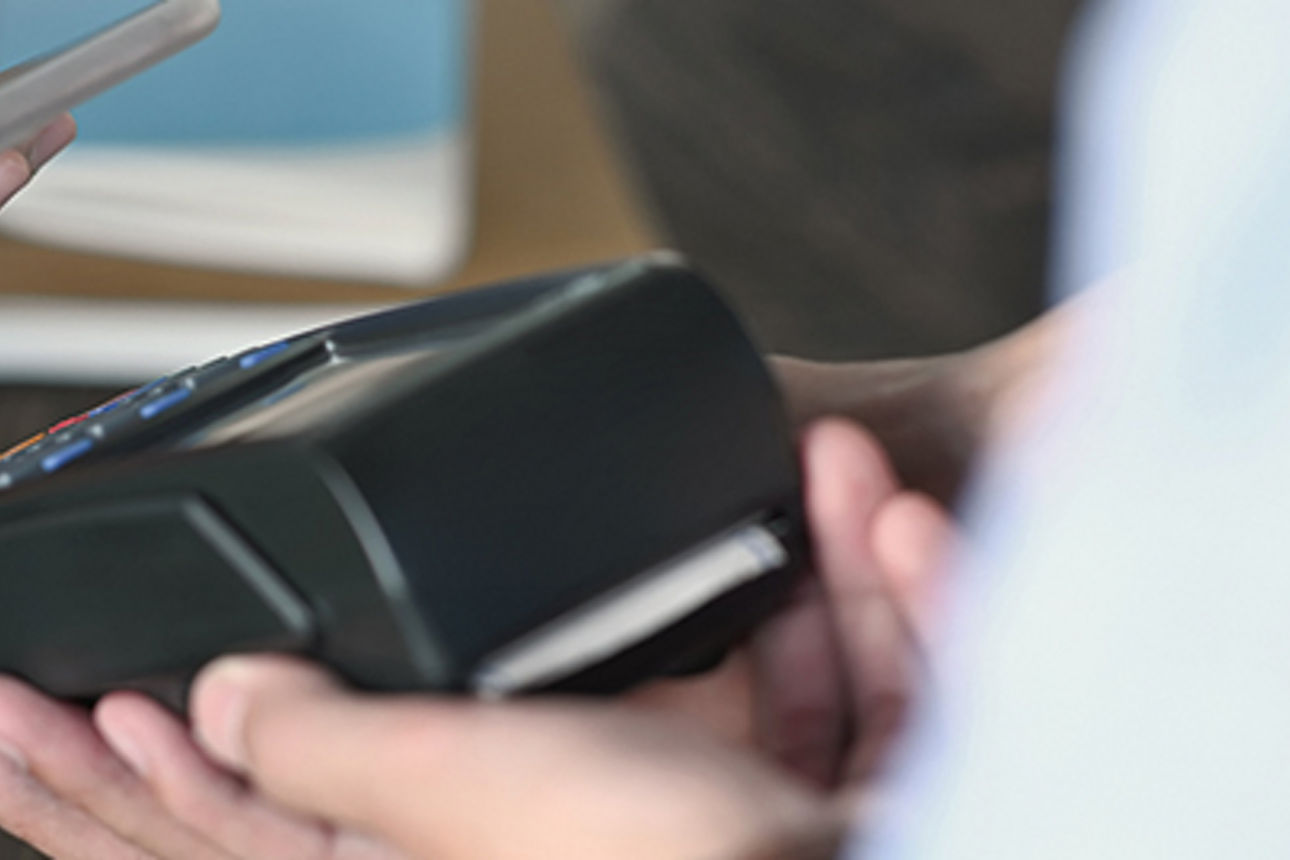 Eine Person, die ein Mobiltelefon in der Hand hält und bereit ist, eine Transaktion durchzuführen.