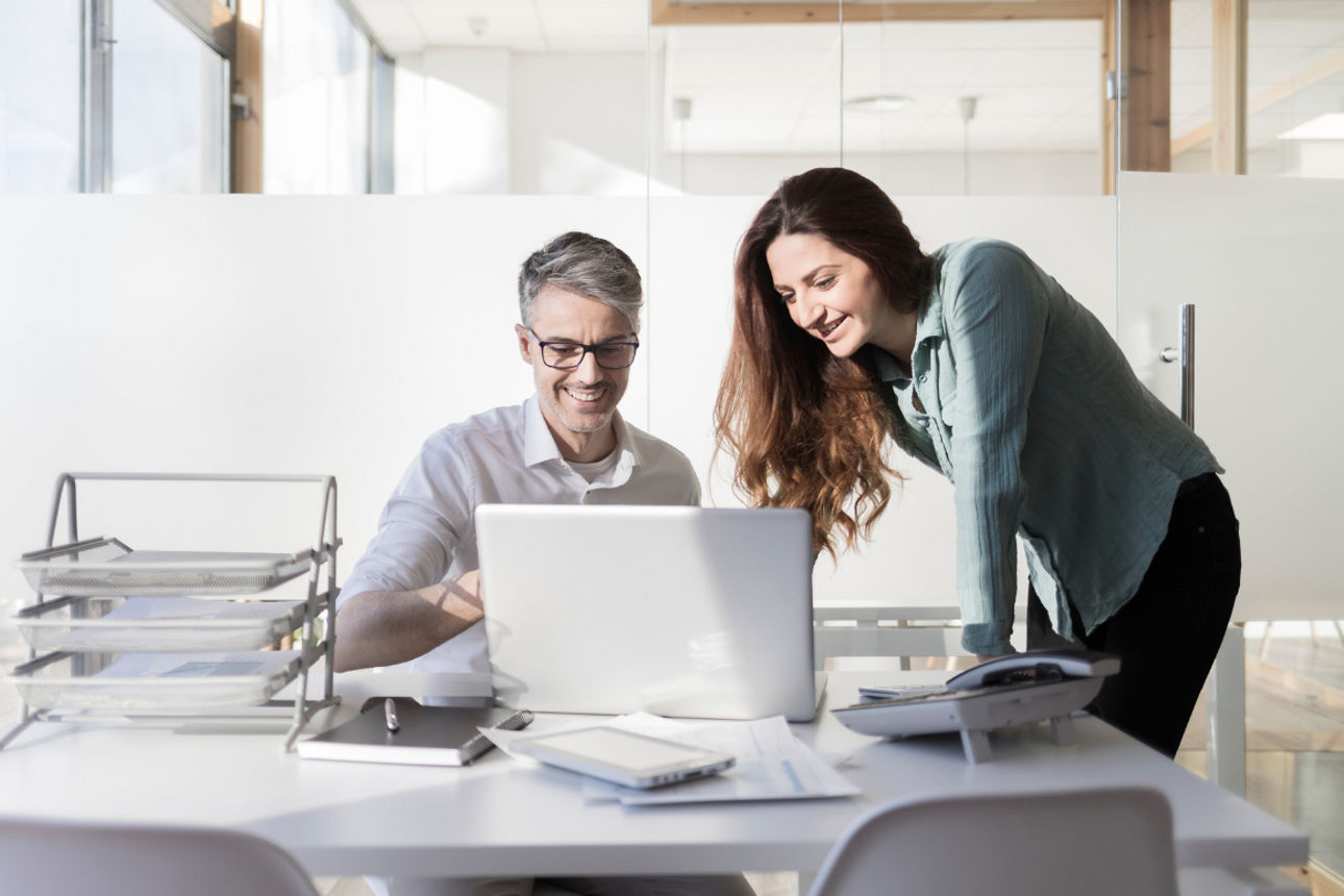Bürosituation - Mann und Frau blicken gemeinsam auf Bildschirm