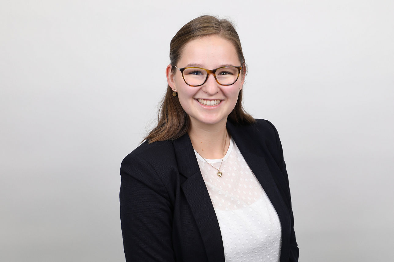 Mitarbeiterin, Victoria Zehn, vor weißem Hintergrund lächelt in die Kamera