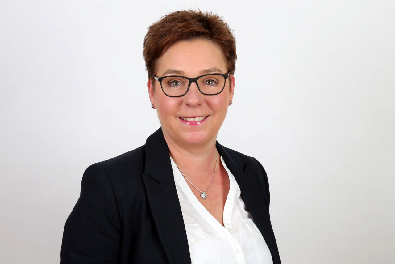 Eine lächelnde Frau schaut in die Kamera.