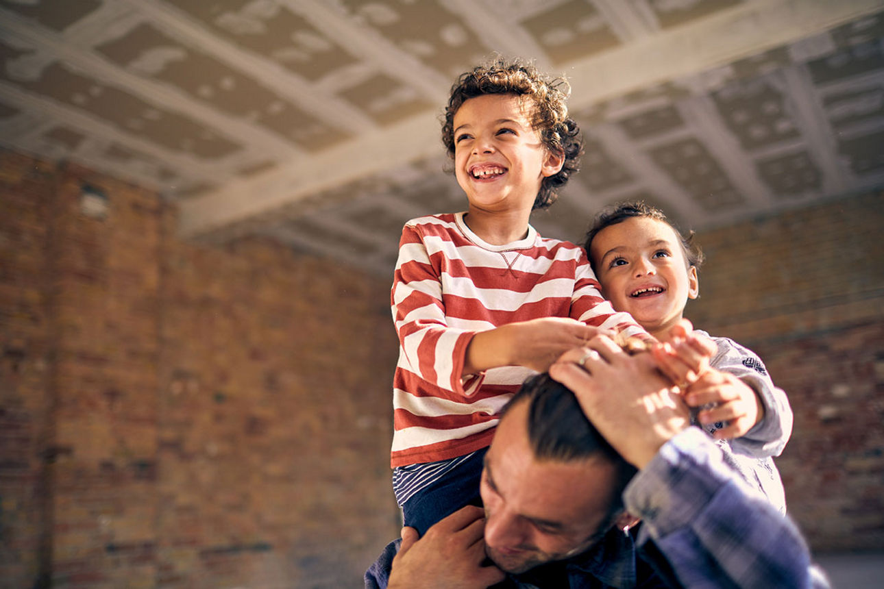 Vater hat zwei Kinder auf den Schultern