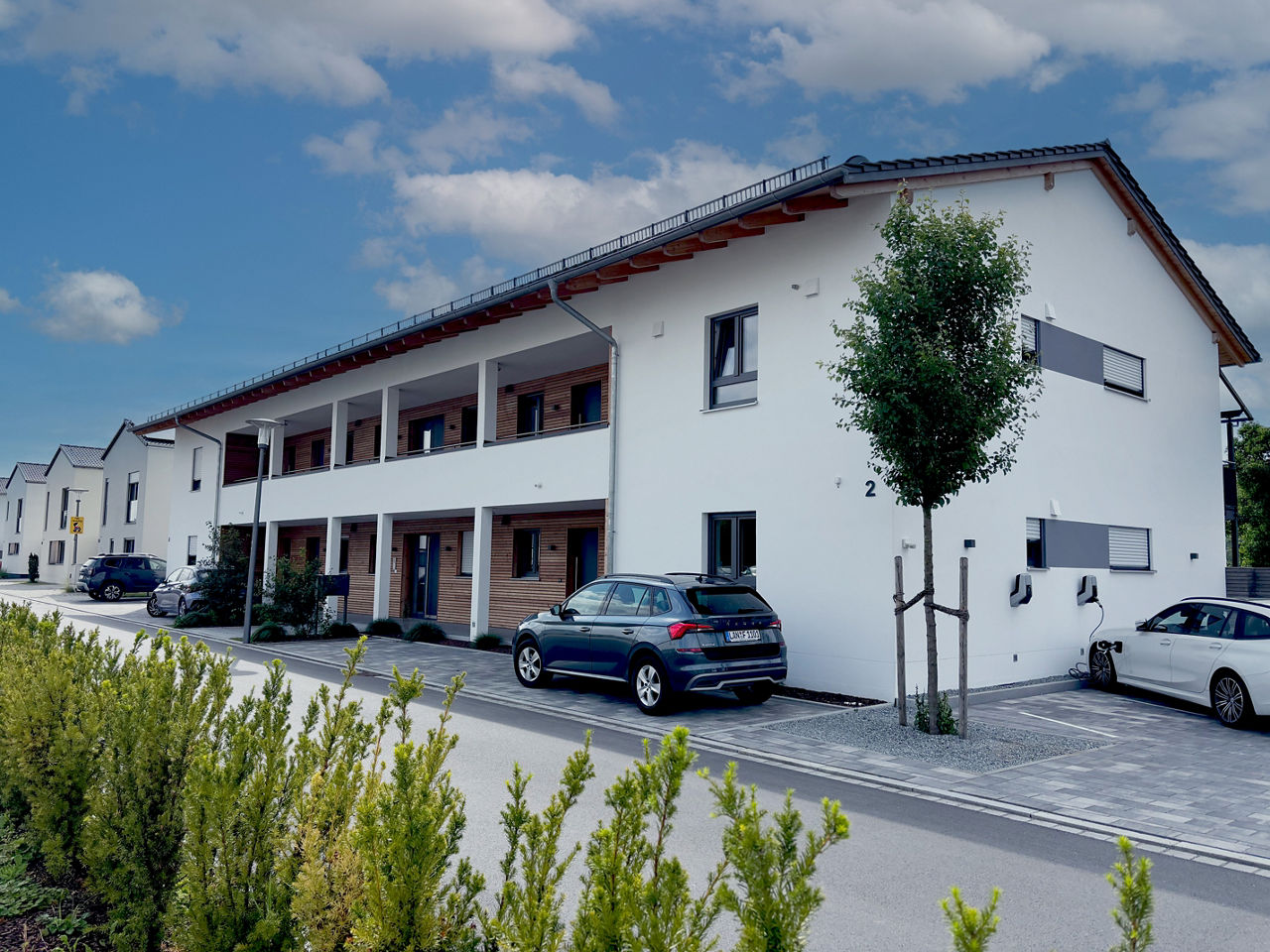 Mehrfamilienhaus mit Straße im Vordergrund