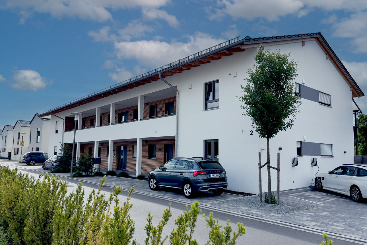 Mehrfamilienhaus mit Straße im Vordergrund