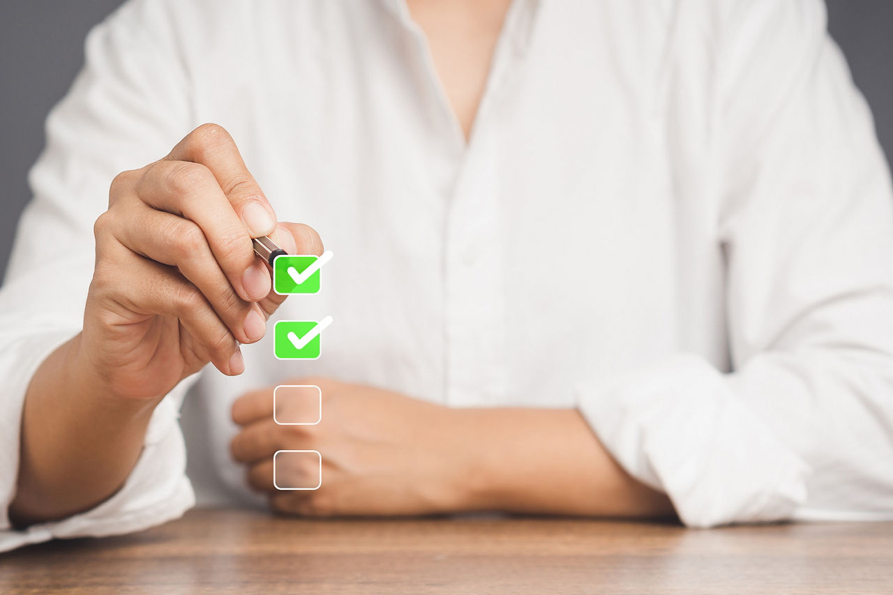 Abbildung zeigt eine Dame, welche mit einem Stift eine Checkbox abhakt und somit ihre Zustimmung gibt