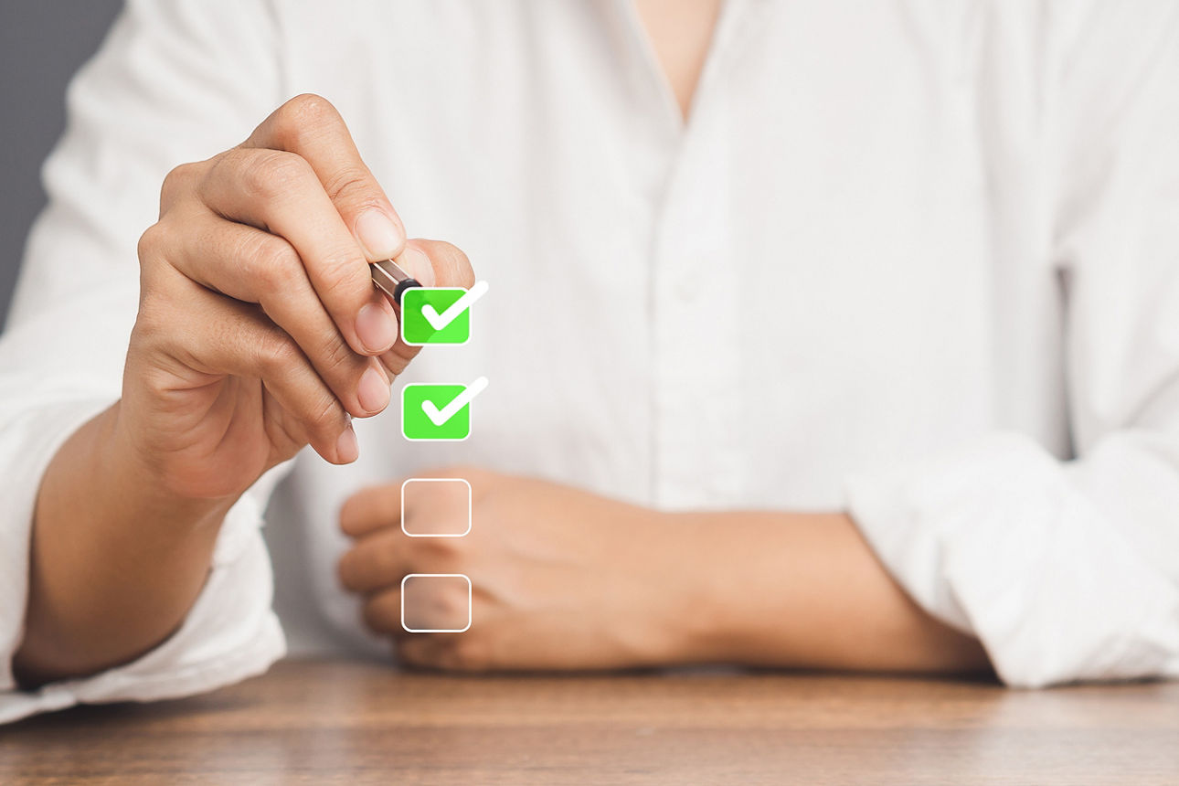 Abbildung zeigt eine Dame, welche mit einem Stift eine Checkbox abhakt und somit ihre Zustimmung gibt