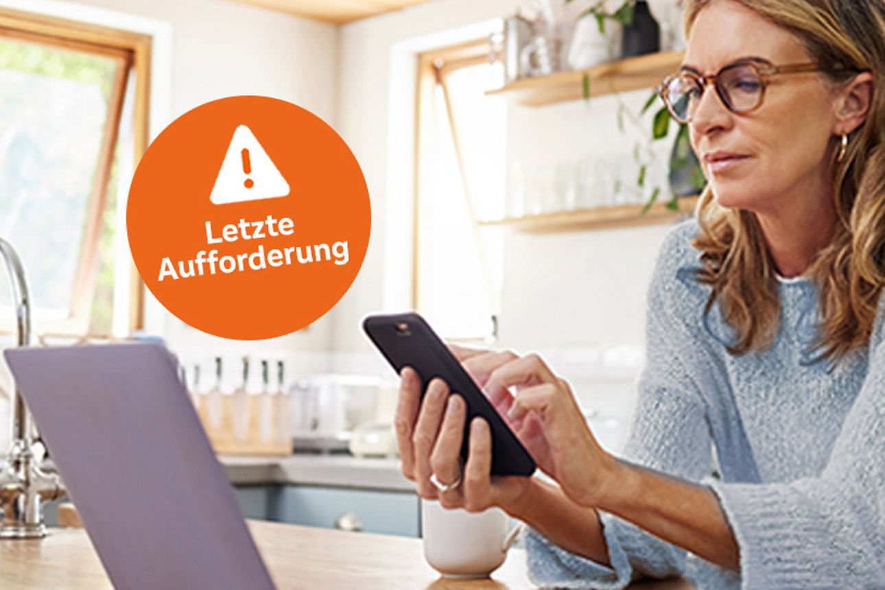 Frau schaut aufs HAndy in ihrer küche und überlegt