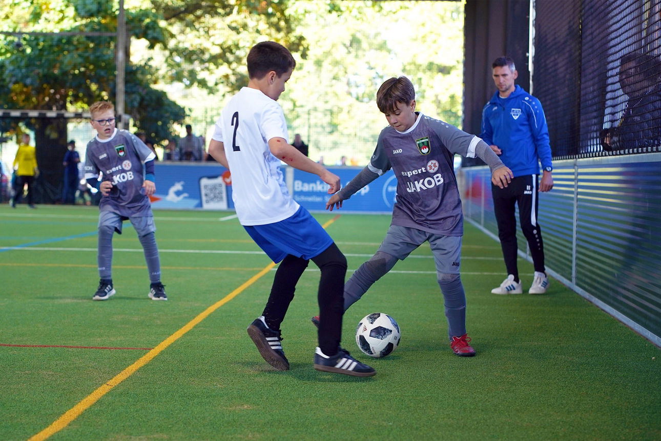 Zweikampf zwischen einem Spieler der JFG Leitenbachtal im grauen Trikot und einem Spieler der blau-weiß gekleideten SG Heroldsbach-Hausen