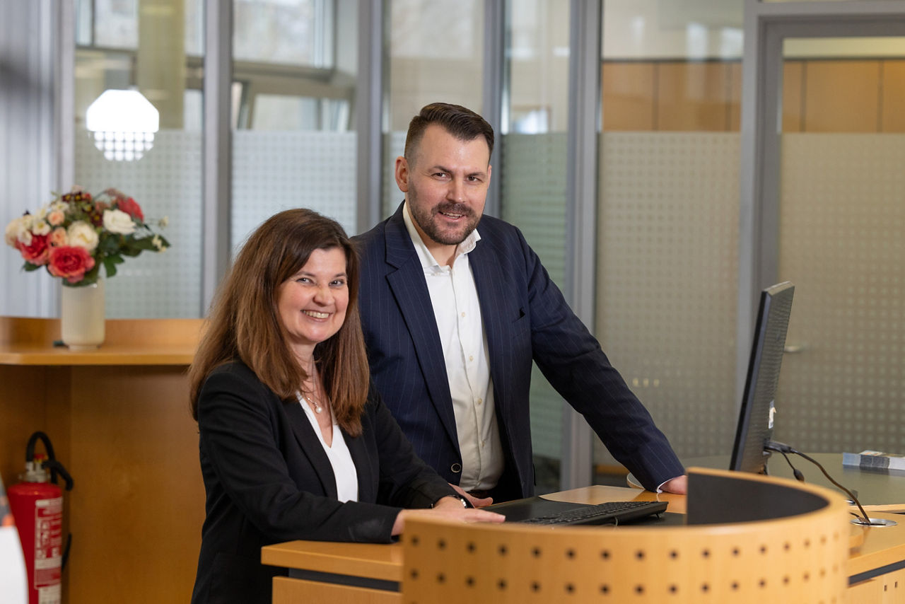 Eine Frau und ein Mann stehen an einem Bankschalter