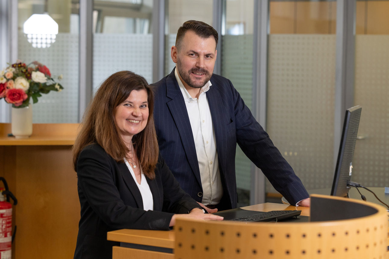 Eine Frau und ein Mann stehen an einem Bankschalter