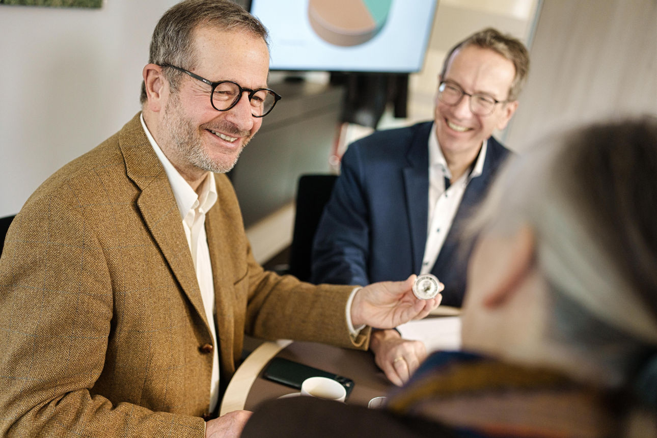 Kundenbetreuer mit zwei Kunden vor einem Bildschirm