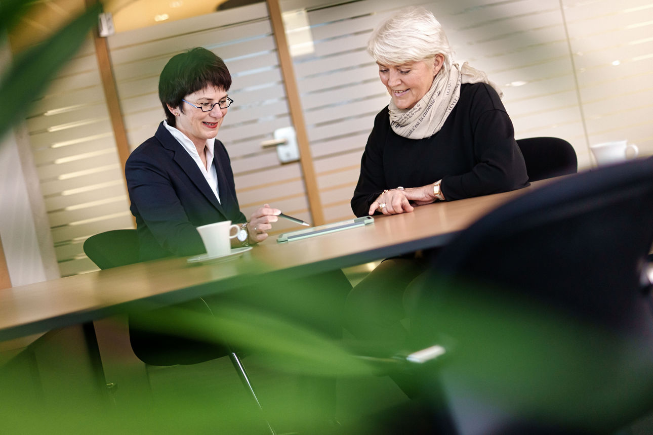 Zwei Frauen in einem Berarungsgespräch die gemeinsam auf ein Tablet schauen