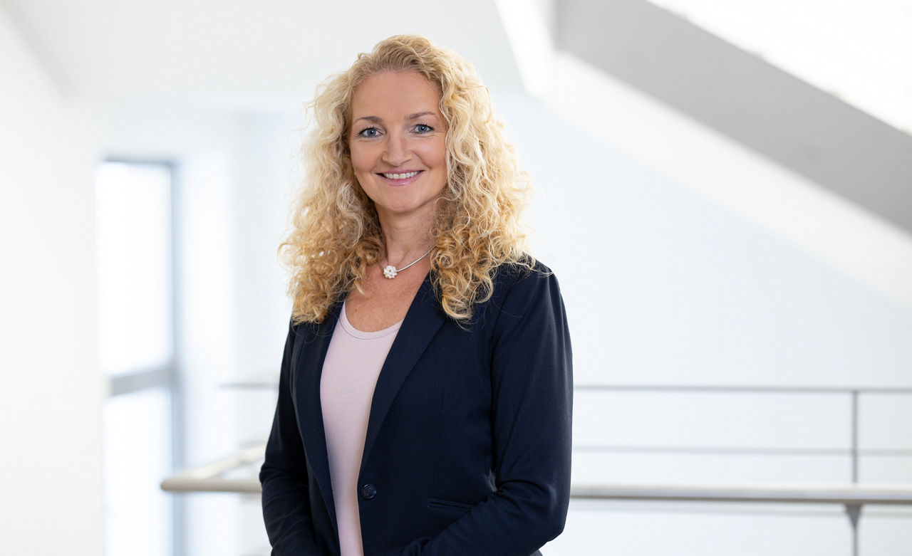 Eine Frau lächelt ins Bild.