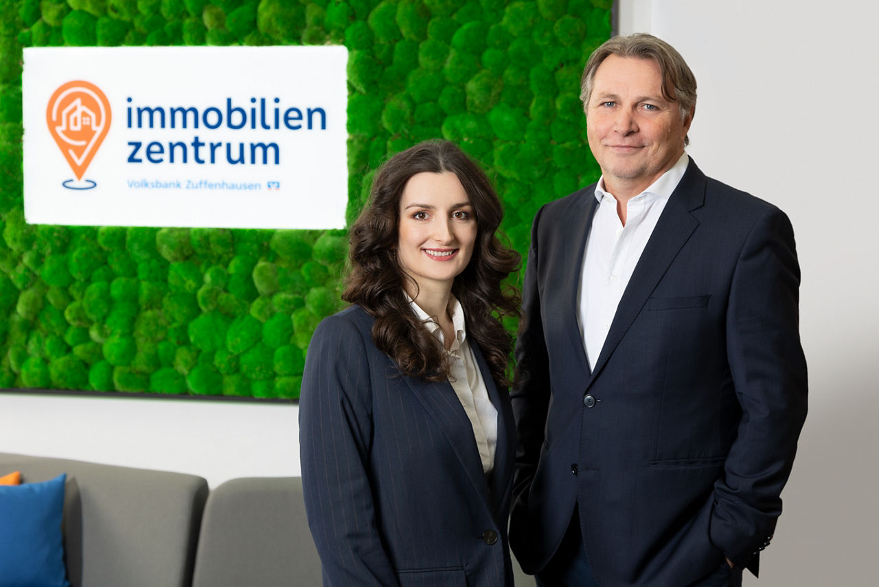 Unsere zwei Makler im immobilien zentrum vor grüner Mooswand
