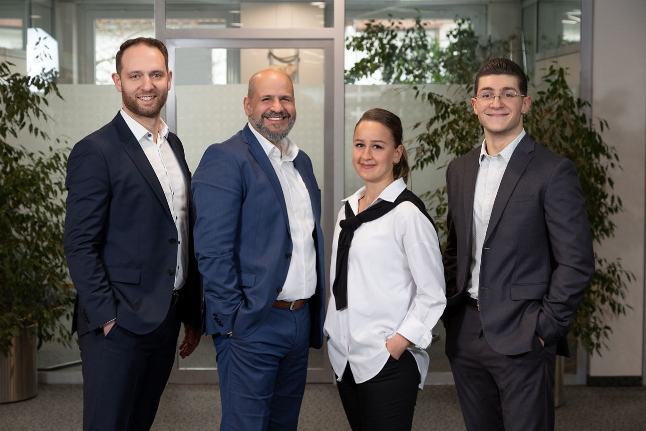 Vier Bankmitarbeiter im Servicebereich einer Bank