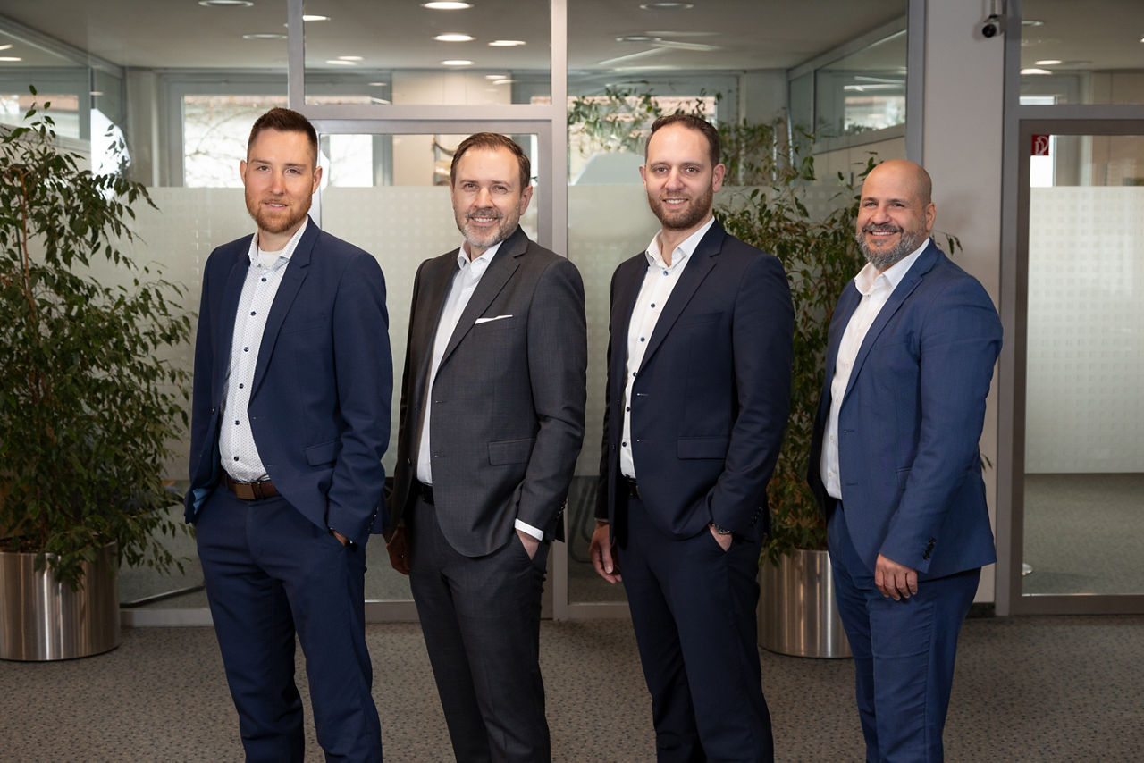 Vier Bankmitarbeiter im Servicebereich einer Bank