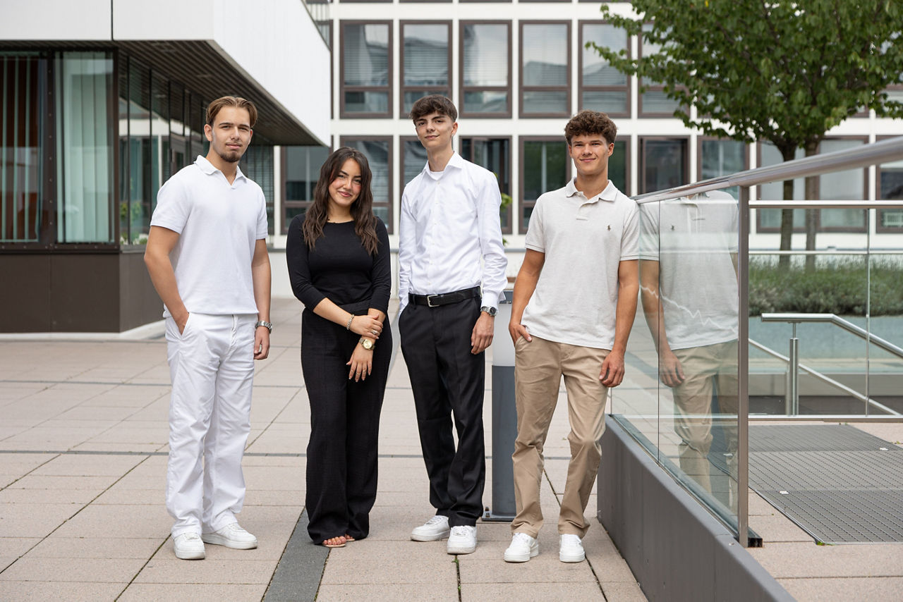 Vier junge Menschen stehen vor einem Gebäude