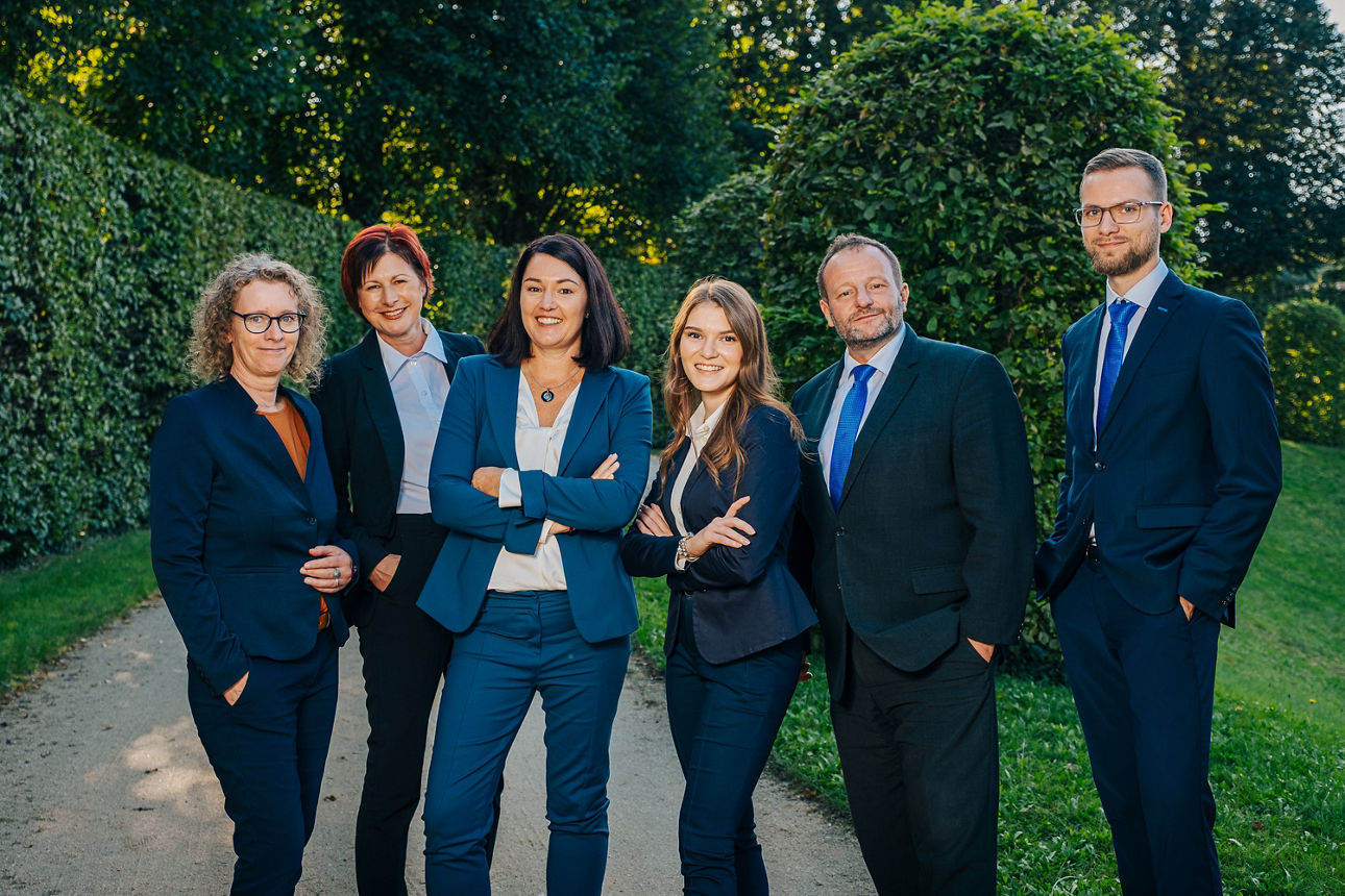 Mitarbeiter in Business-Kleidung posieren im Barockgarten