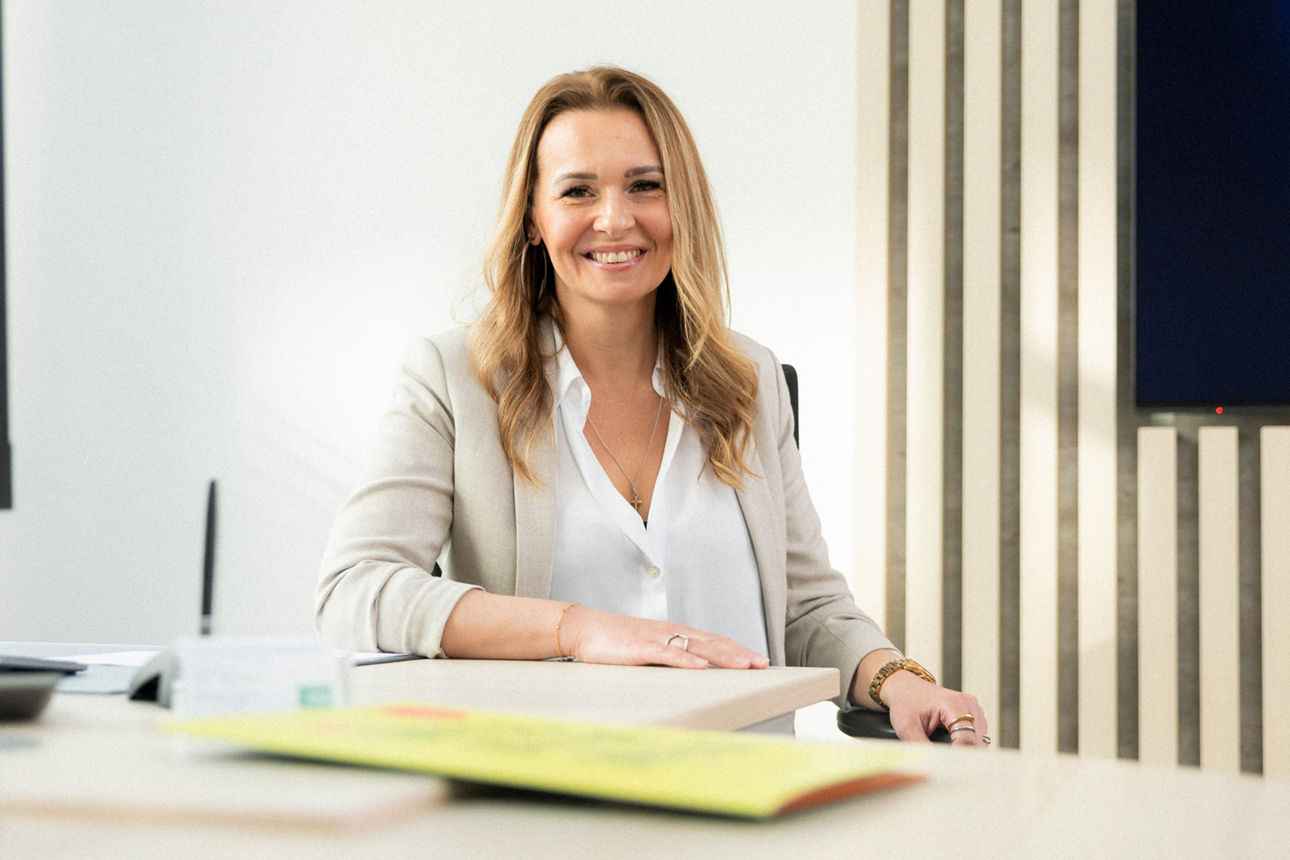 Eine Frau sitzt am Tisch vor dem Computer