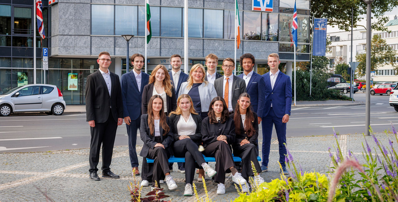 Menschen stehen und sitzen vor einem Bankgebäude 