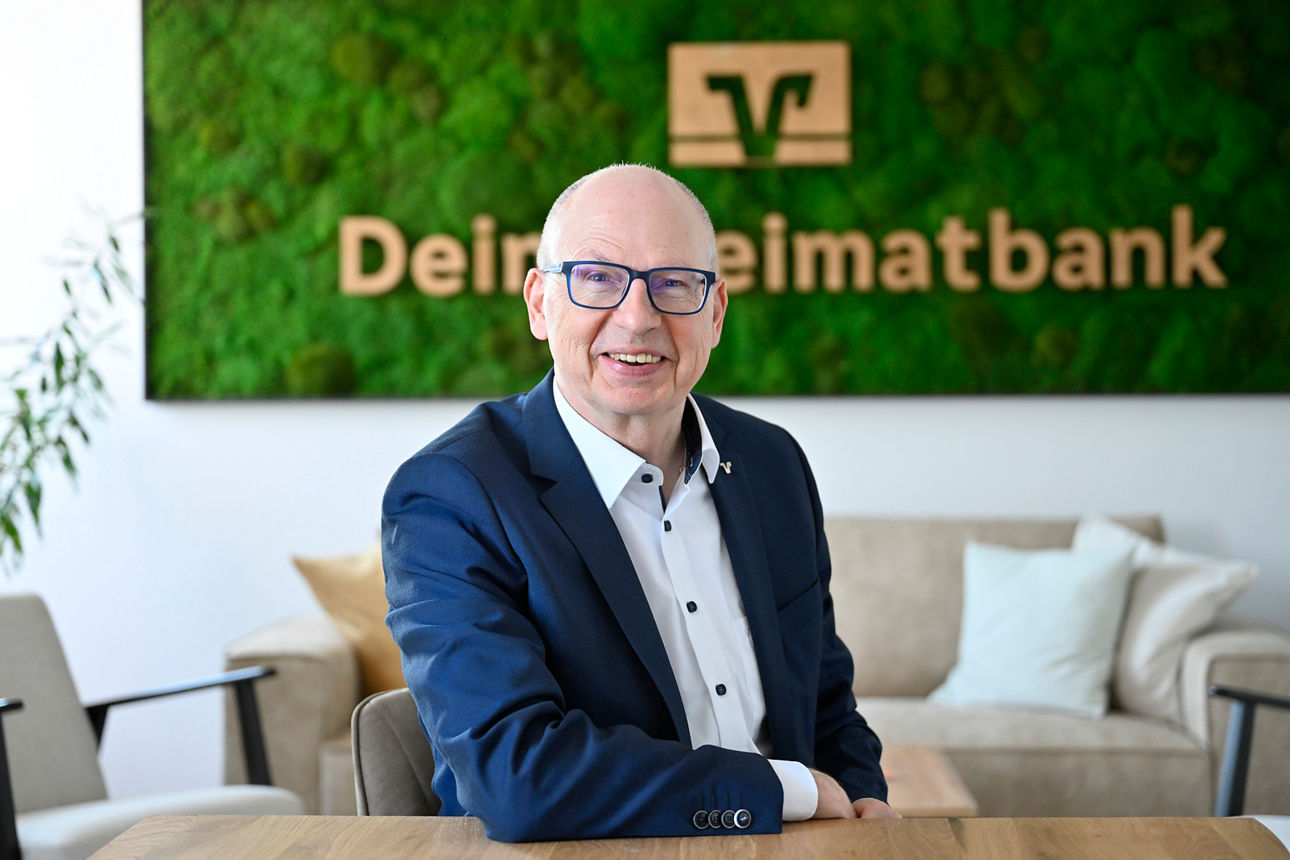 Vorstandsmitglied Bosch vor dem Heimatbanklogo