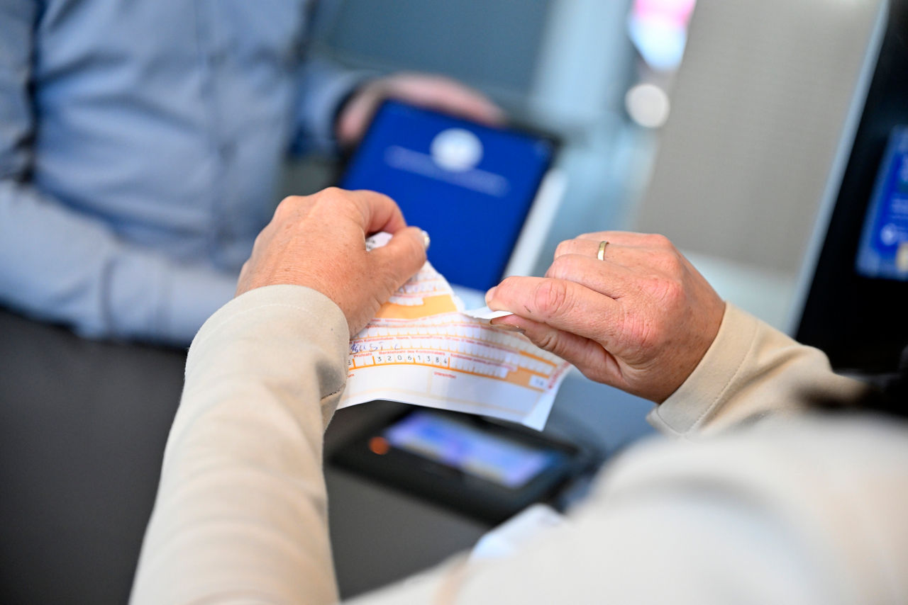 Eine zerrissene Überweisung und dahinter ein I Pad mit Online Banking