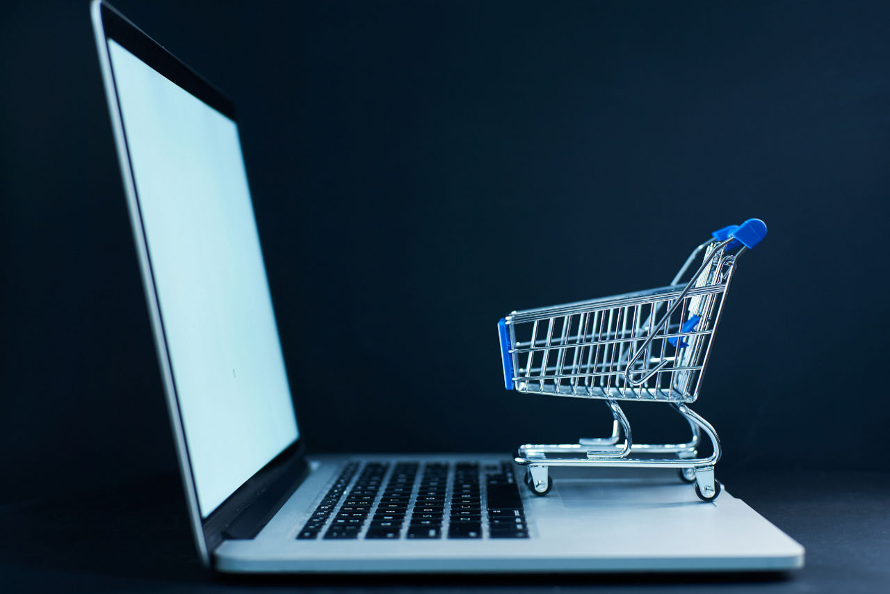 Einkaufswagen Miniatur auf offfenem Laptop stehend
