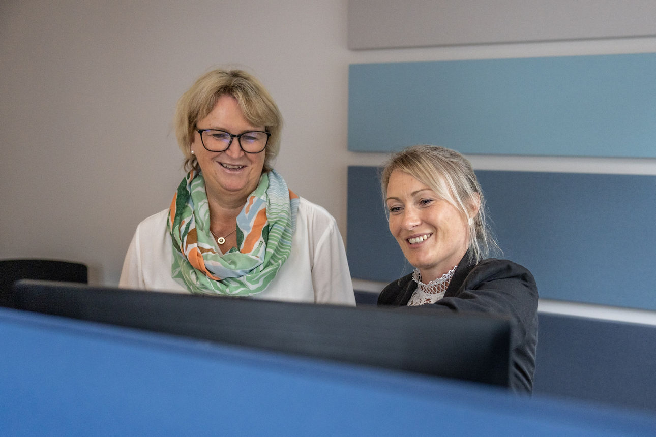 Zwei Geschänftskundenbetreuerinnen sitzen gemeinsam vor ihrem Computer