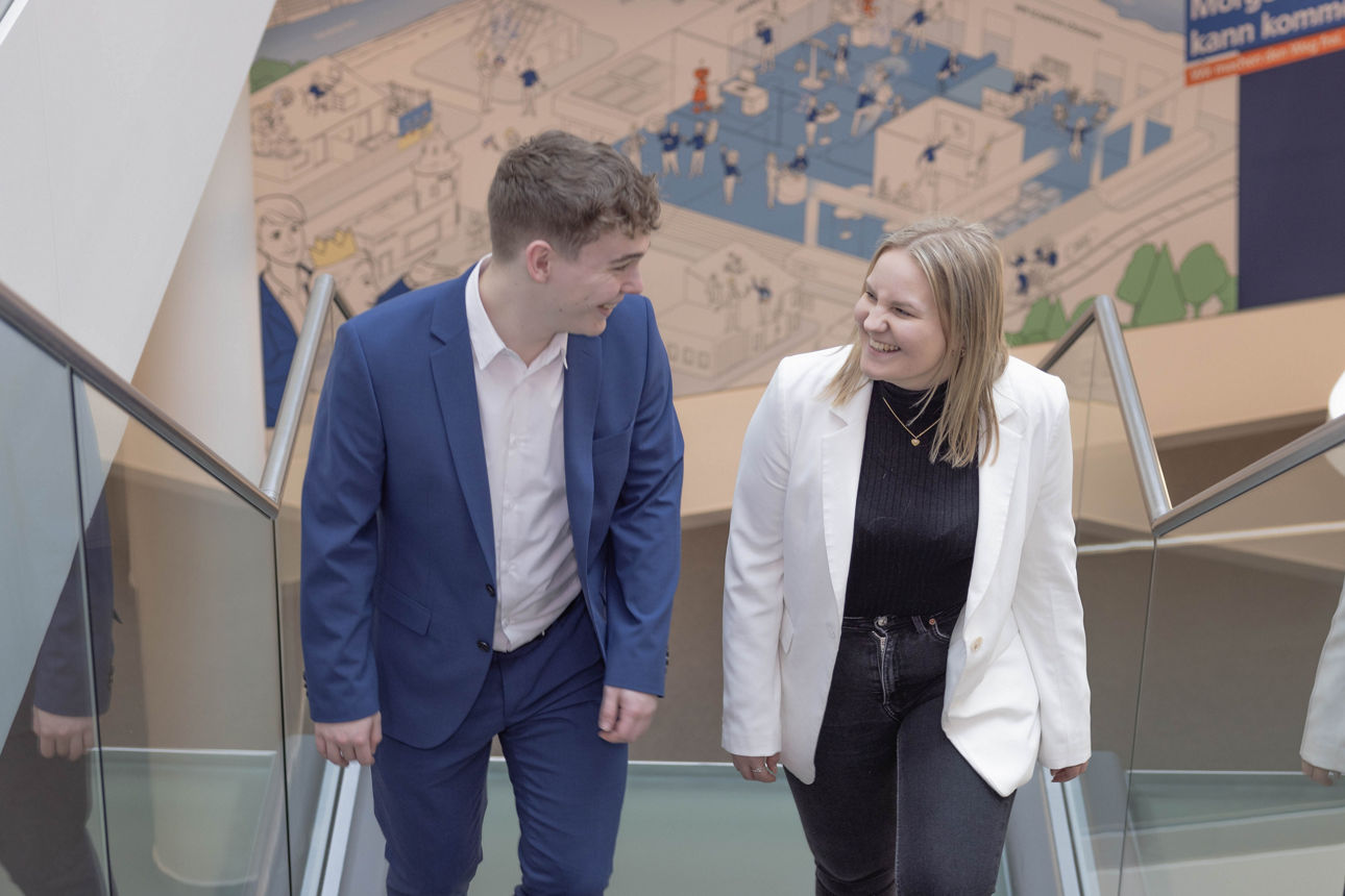 Auszubildende unterhalten sich während sie die Treppe hochgehen