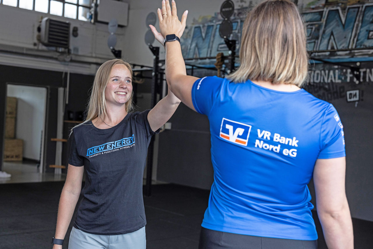 Zwei Frauen in Sportkleidung klatschen sich gegenseitig ab