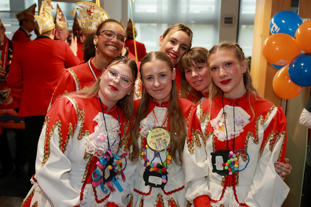Eine Tanzgruppe in rot-weißen Gardeuniformen hat sich zum Gruppenfoto aufgestellt