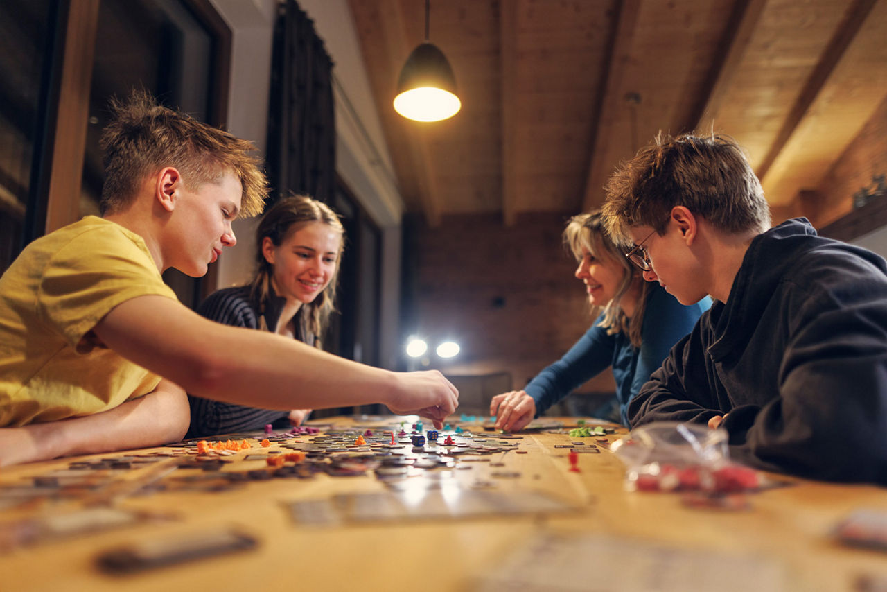 Jugendliche sitzen am Tisch und spielen