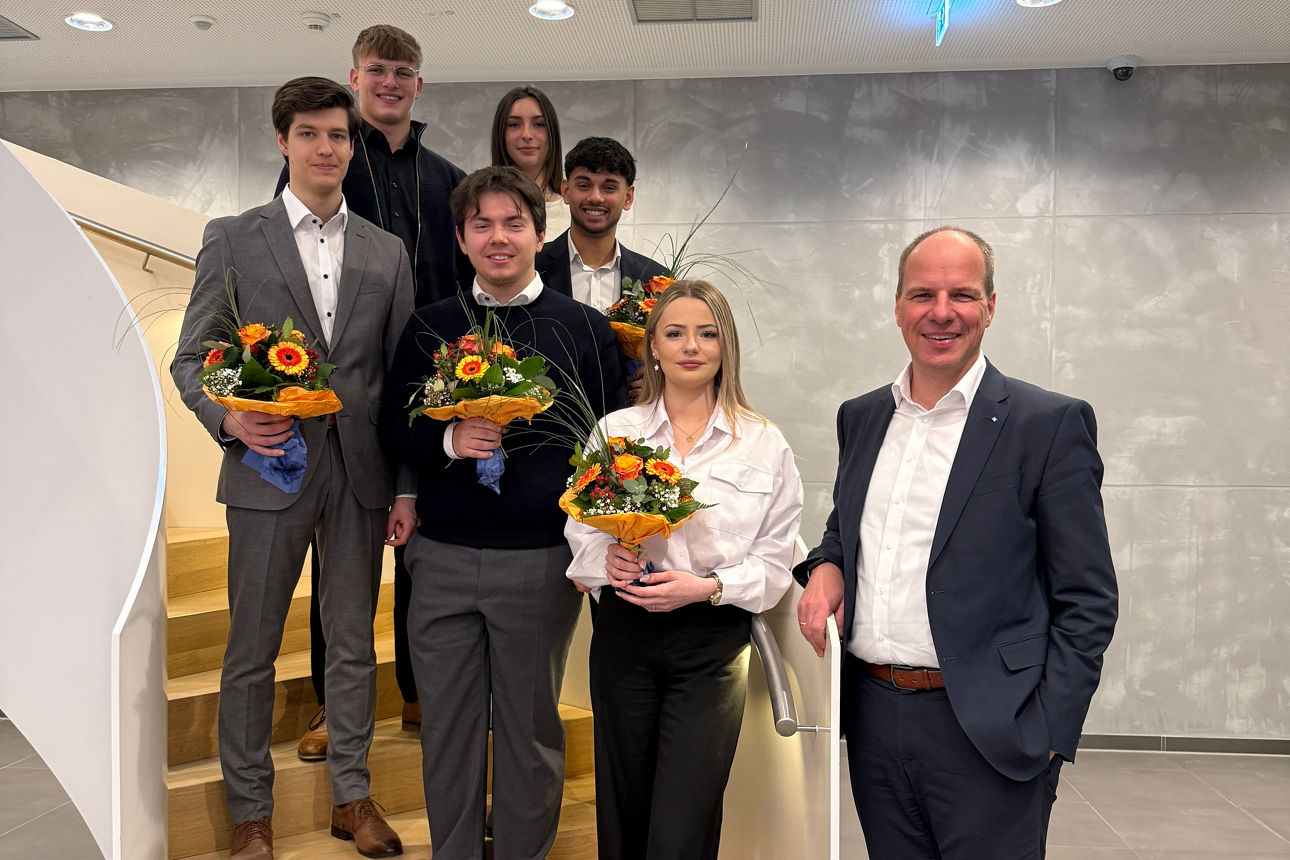 Viele Menschen stehen lächelnd Richtung Kamera.