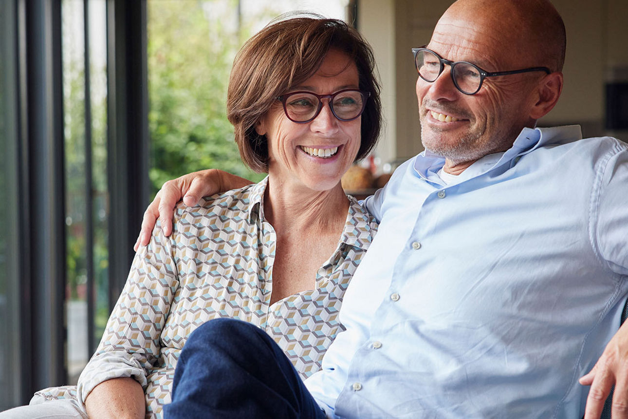 Eine Frau und ein Mann sitzen auf dem Sofa und freuen sich