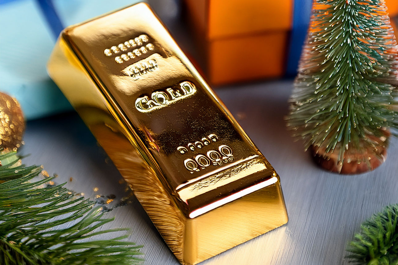 Ein Goldbarren liegt neben Weihnachtsgeschenken.