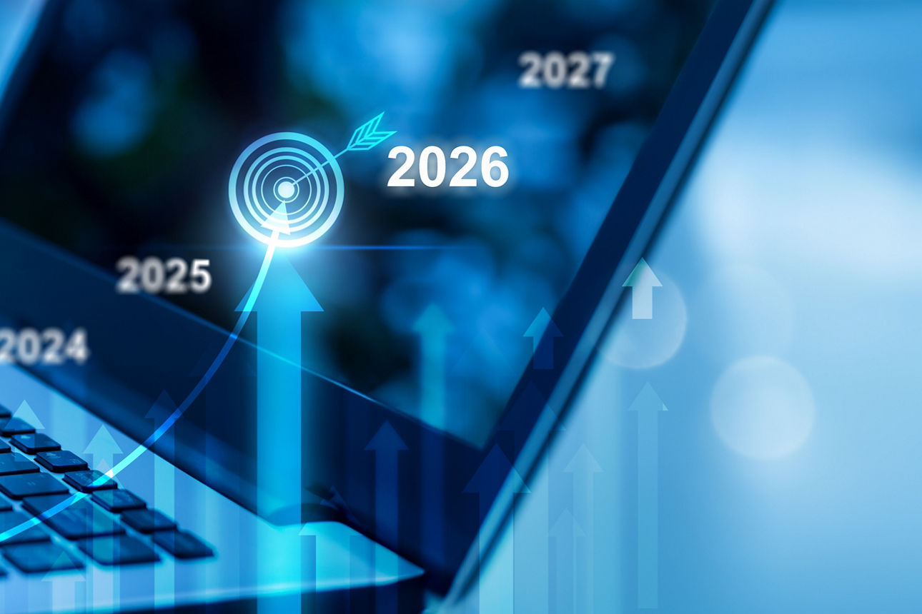 Hände tippen auf Laptop, im Vordergrund Zeitleiste mit Jahren, 2026 hervorgehoben, alles in Blautönen