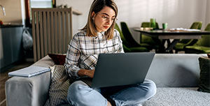 Eine Frau schaut auf einen Laptop.