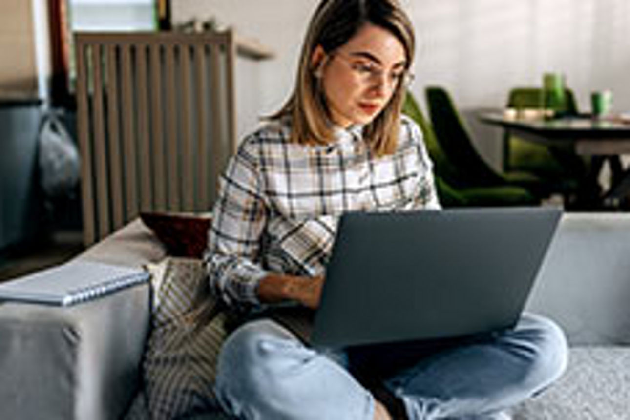 Eine Frau schaut auf einen Laptop.