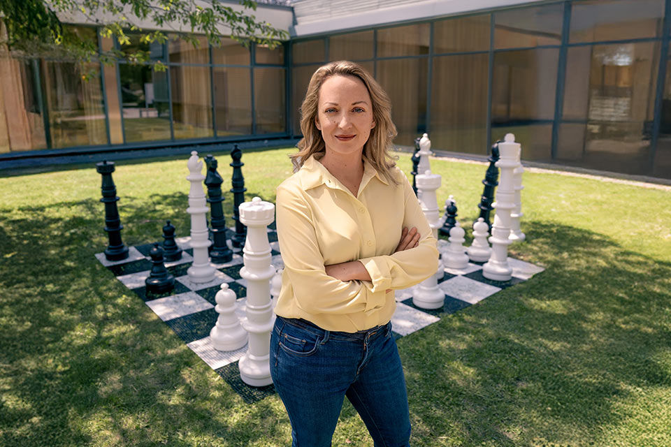 Elisabeth Pähtz, die Schachgroßmeisterin, vor einem Riesen-Schachspiel auf einer Rasenfläche in einem Hof