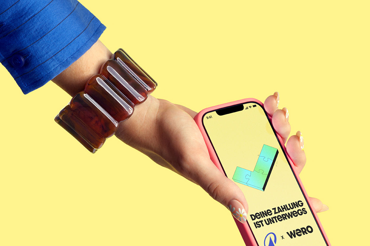 Hand hält Handy hoch mit Wero-Werbung