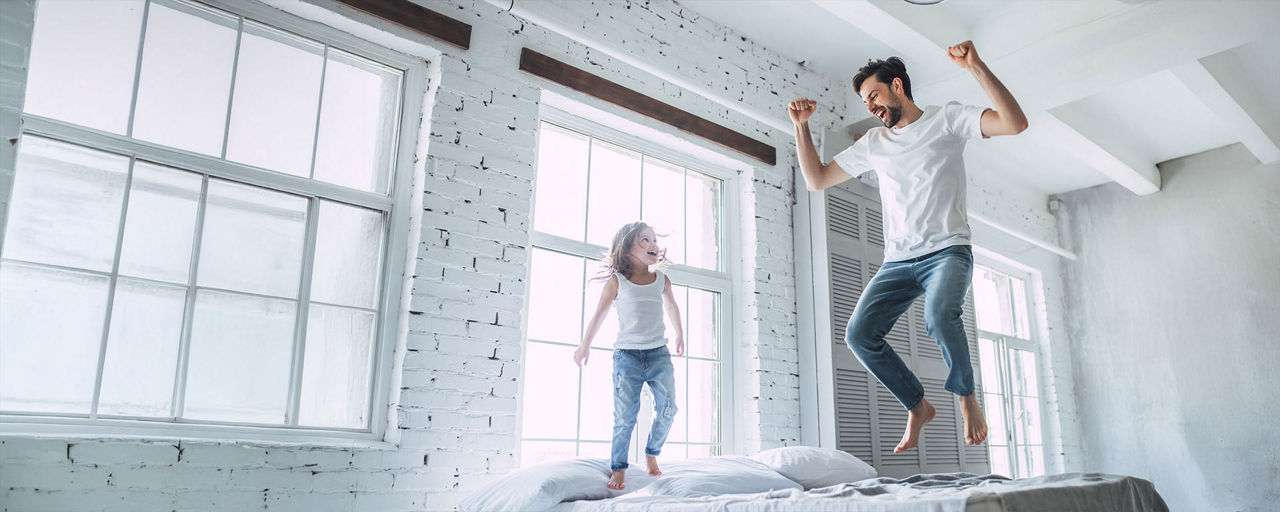 Vater und Tochter springen in die Luft
