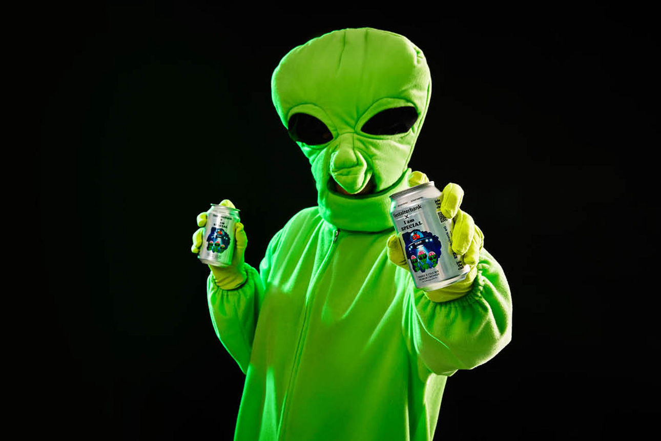 Ein Alien mit 2 Dosen Alienelixier in den Händen
