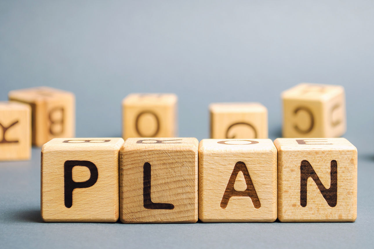 Bild von Holzklötzen auf denen Buchstaben stehen, die das Wort Plan ergeben.