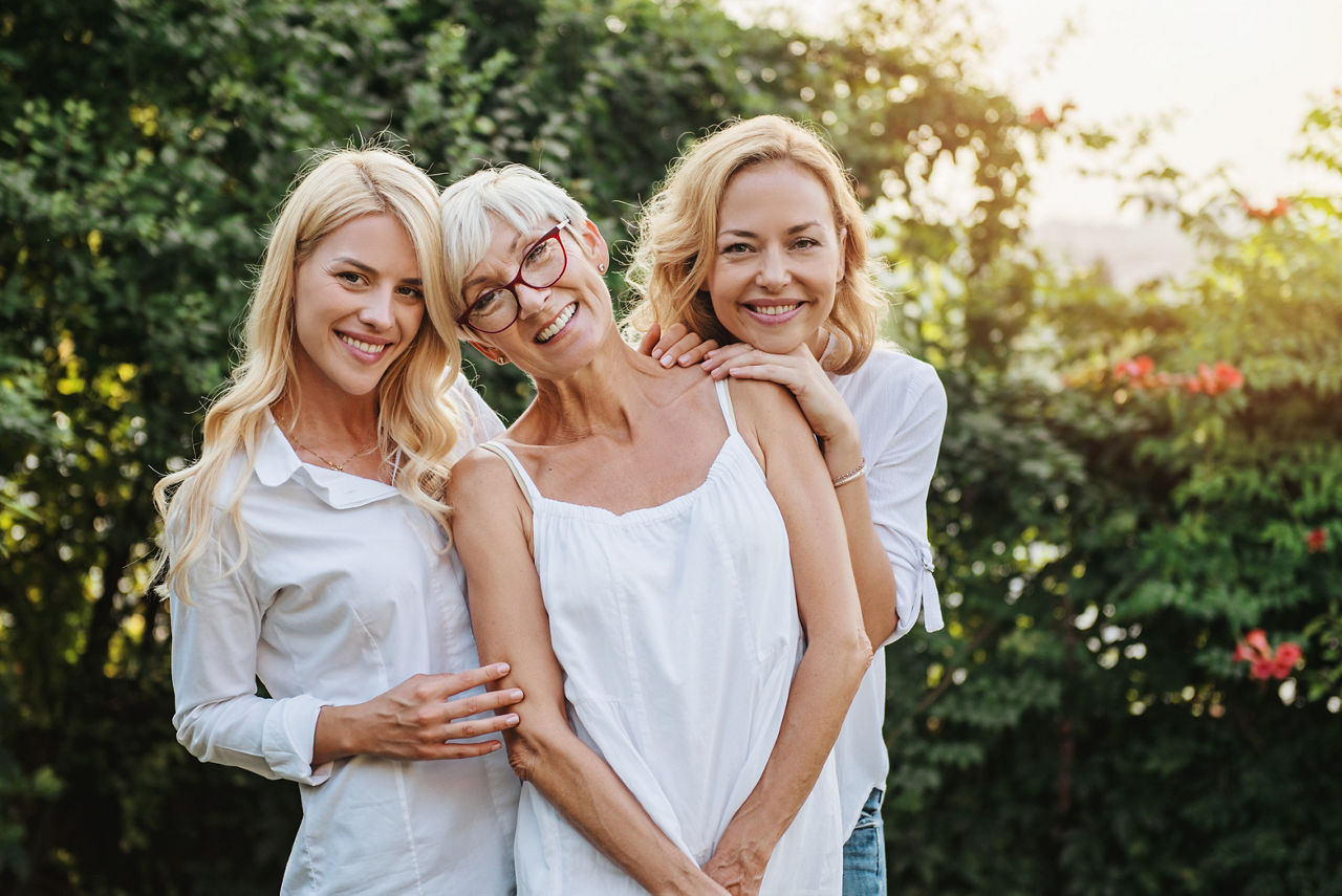 Drei Frauen in verscheidenen Altersklassen gucken fröhlich in die Kamera