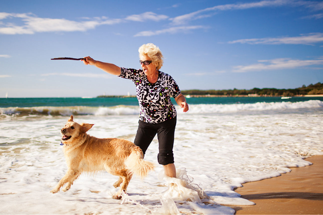 Frau mit Hund am Strand